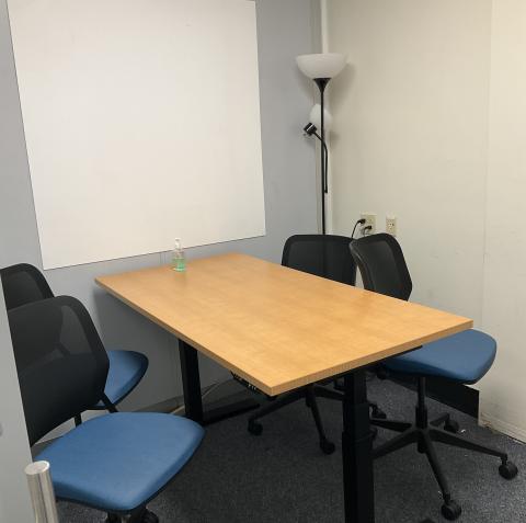 Small Room with a table, lamp,  whiteboard, small table & 4 chairs.