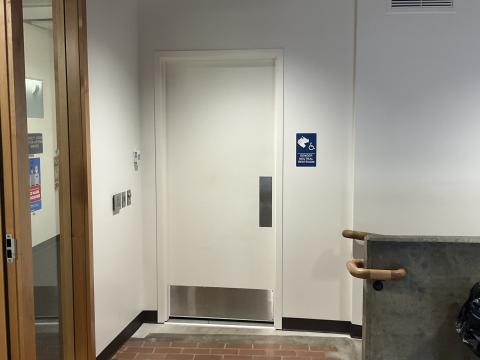 A closed door for a gender-neutral restroom. Windows into DAC on left.  