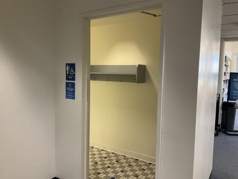 Open doorway into men's restroom. Tiled flooring.